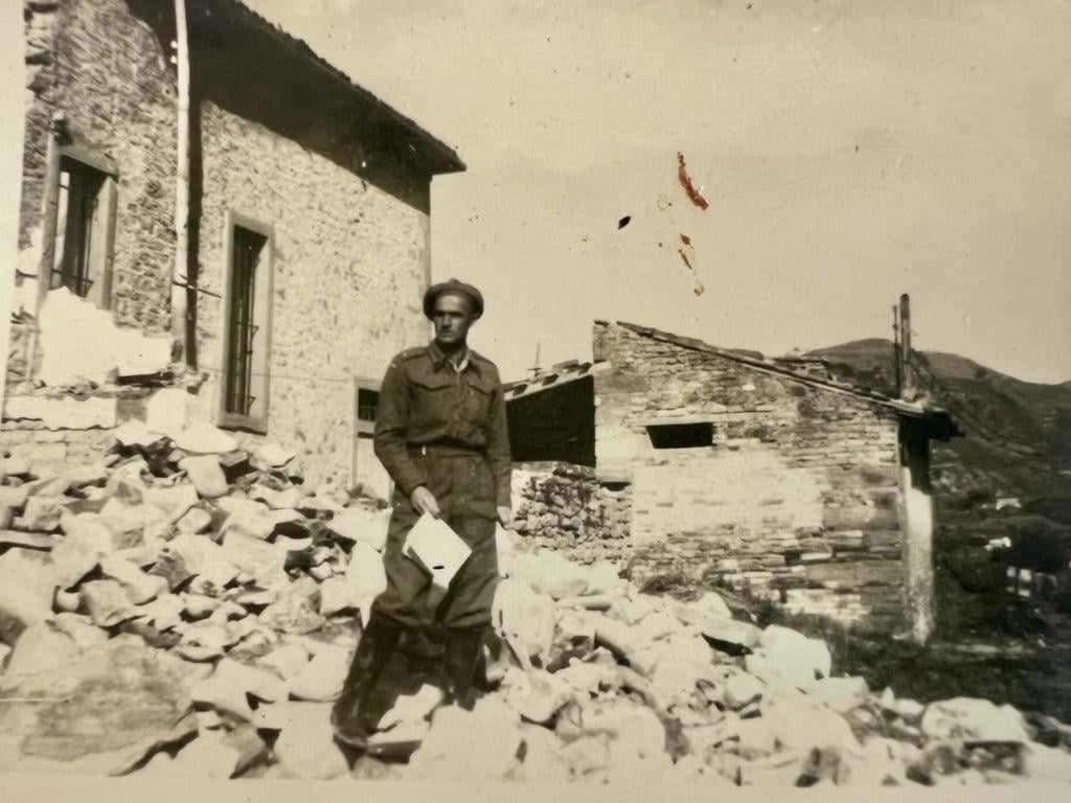 Adam Malach w mundurze wśród zniszczonej zabudowy w Galeacie, 24 października 1944 roku — według podpisu fotografii